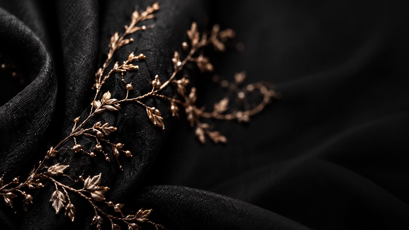Black net scattered with rose-gold beaded sprigs, lit from the side